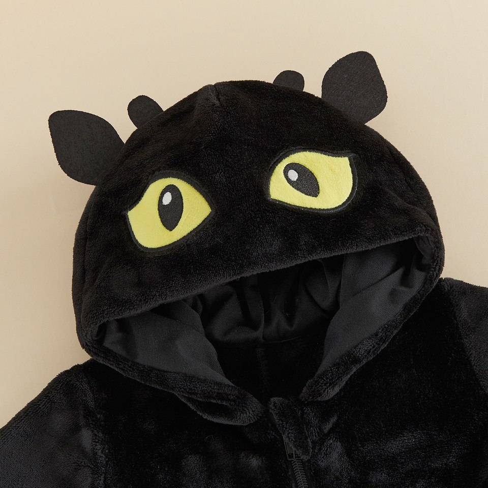 Détail de la capuche de dragon noir avec yeux jaunes brodés et petites cornes