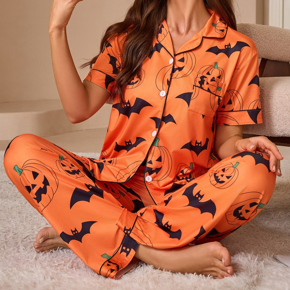 Détail du haut de pyjama Halloween orange avec citrouilles, chauves-souris et poche poitrine