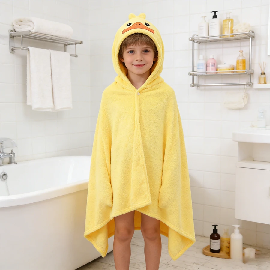 Enfant enveloppé dans la grande serviette de bain à capuche jaune, motif canard